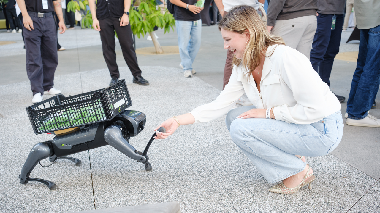 A college grad interacting with a robot dog at the NVIDIA MBA program