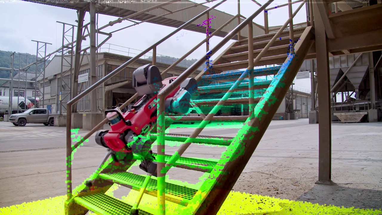 A robot navigates a stairway, with highlighted path visualizations in blue and green