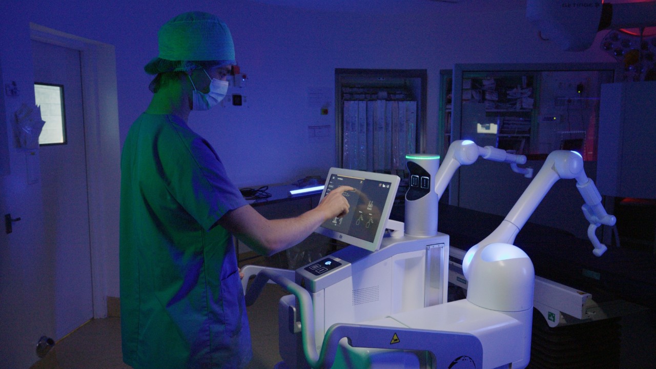 A doctor operates a surgical robotics system