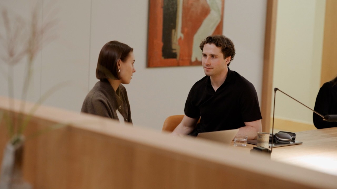 Two individuals engaged in conversation within a modern office
